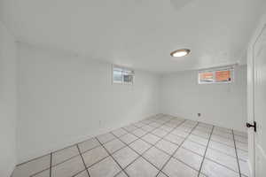 Basement featuring light tile patterned floors and plenty of natural light