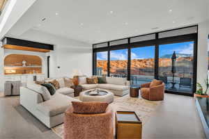 Living room with floor to ceiling windows, bar with sink, a mountain view, and recessed lighting