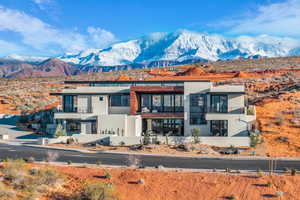View of front of house featuring a mountain view, a balcony, and stucco siding