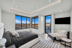 Bedroom with access to exterior, a raised ceiling, and recessed lighting