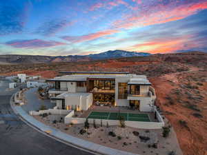 Back of house at dusk with a balcony, stucco siding, and a mountain view