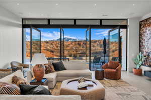 Living area with expansive windows, a mountain view, finished concrete floors, and plenty of natural light