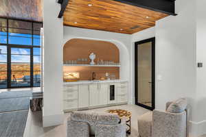 Indoor wet bar featuring wood ceiling, white cabinets, floor to ceiling windows, open shelves, and recessed lighting