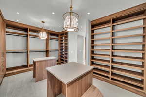 Spacious closet with a chandelier and light tile patterned flooring