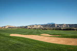 View of home's community with a mountain view, golf course view, and a lawn