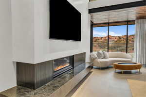 Living area with a glass covered fireplace and floor to ceiling windows