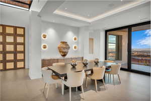 Dining room featuring floor to ceiling windows, light tile patterned floors, a tray ceiling, and recessed lighting
