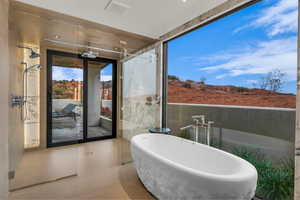 Full bathroom with a freestanding bath and a marble finish shower