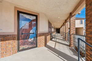 Doorway to property featuring stucco siding and brick siding