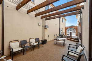 View of patio / terrace with a wall unit AC and a pergola