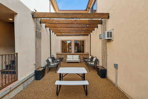 View of patio featuring an outdoor hangout area, a wall mounted AC, and a pergola