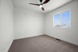 Carpeted empty room with ceiling fan