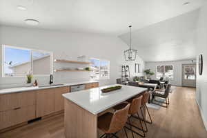 Kitchen featuring a kitchen island, pendant lighting, a wealth of natural light, sink, and stainless steel dishwasher