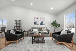 Living room with plenty of natural light, vaulted ceiling, and light hardwood / wood-style flooring