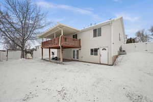 Snow covered house with a deck