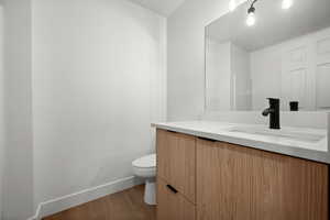 Bathroom featuring vanity, toilet, and hardwood / wood-style floors