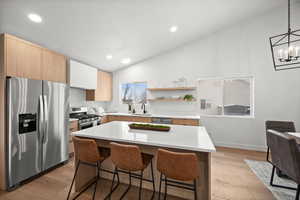 Kitchen featuring pendant lighting, sink, stainless steel appliances, and a center island