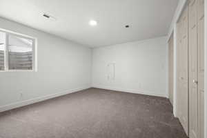 Unfurnished bedroom featuring dark carpet and a closet