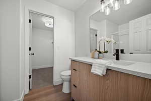 Bathroom featuring vanity, hardwood / wood-style floors, toilet, and walk in shower