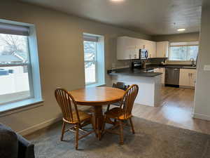 Dining area with sink, hardwood / wood-style floors, and a textured ceiling