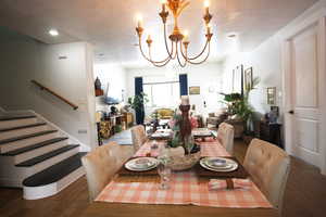 Dining room with wood-tile flooring, a chandelier, and a textured ceiling