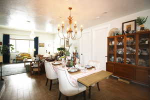 Dining room with wood-tile flooring, a textured ceiling, and a notable chandelier