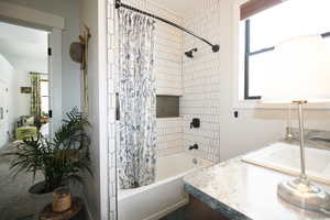 Main Bathroom featuring tile shower / bath combo and vanity with Natural Light pouring in.