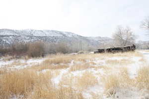 Snowy landscape with a mountain view and old rustic horse barn