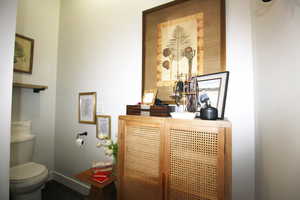 Private space with toilet, vanity, and backsplash