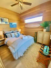 Bedroom with wooden walls and ceiling fan