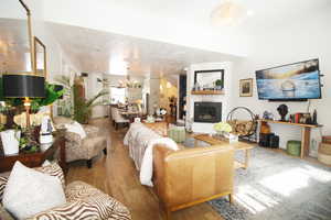 Living room with an inviting chandelier, wood-tile flooring, and a vaulted ceiling