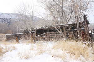 Snowy landscape with a mountain view and old rustic horse barn