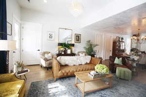 Living room with light wood-tile flooring and a chandelier