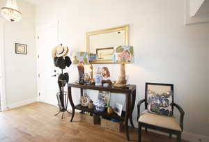 Hallway with a notable chandelier and light hardwood / wood-style flooring