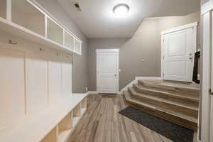 Mudroom featuring wood-type flooring and a textured ceiling