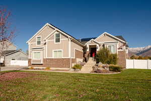 Craftsman house featuring a mountain view, a front yard, and solar panels