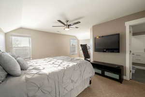 Carpeted bedroom featuring lofted ceiling and ceiling fan