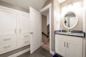 Bathroom with vanity, vaulted ceiling, and tile patterned floors