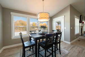 Dining room with vaulted ceiling and light wood-type flooring