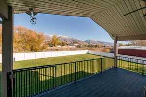 Wooden terrace featuring a yard and a mountain view