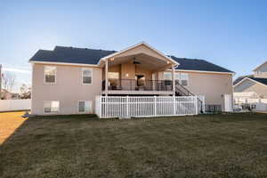 Back of property featuring ceiling fan and a lawn