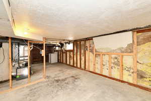 Basement with washer / dryer and a textured ceiling