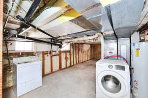 Clothes washing area with plenty of natural light, washer / clothes dryer, and water heater