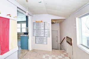 Hallway featuring heating unit and vaulted ceiling