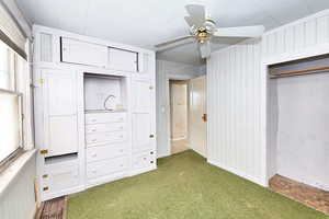 Unfurnished bedroom featuring crown molding, ceiling fan, dark parquet flooring, and a closet