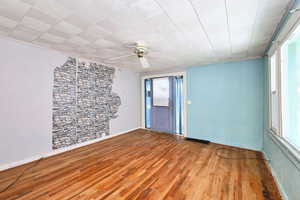 Empty room featuring ceiling fan and wood-type flooring