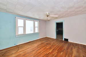 Empty room with hardwood / wood-style floors and ceiling fan