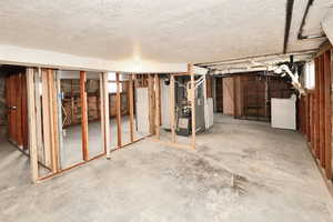 Basement with washer / dryer and a textured ceiling