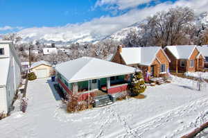 View of front of home with a garage, a mountain view, a porch, and an outbuilding