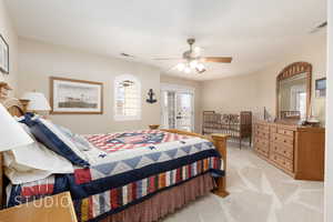 Bedroom featuring french doors, light colored carpet, access to exterior, and ceiling fan